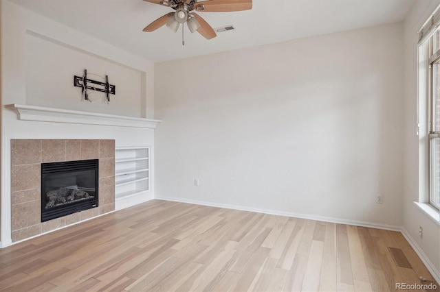 unfurnished living room featuring ceiling fan, a healthy amount of sunlight, light wood finished floors, and visible vents