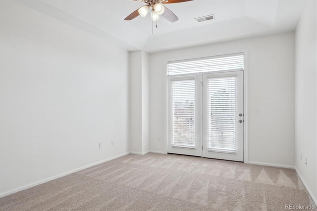 empty room with ceiling fan, visible vents, baseboards, and light carpet