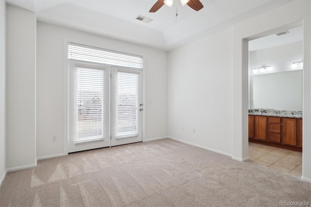spare room featuring ceiling fan, light carpet, visible vents, and baseboards