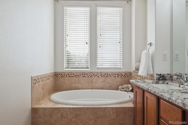 bathroom with a bath, vanity, and a wealth of natural light