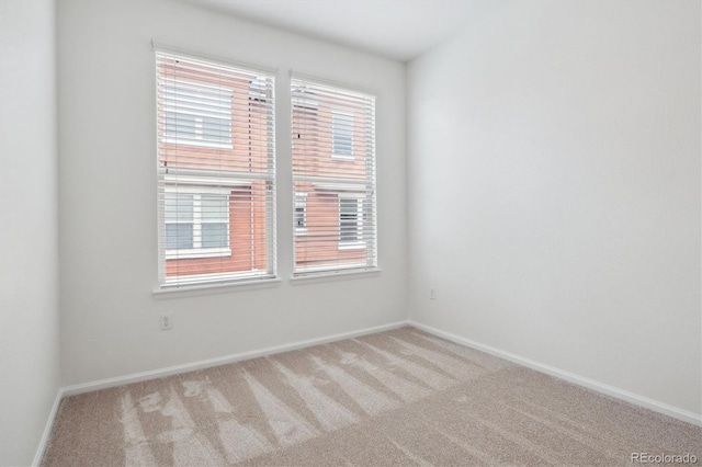 carpeted empty room with baseboards