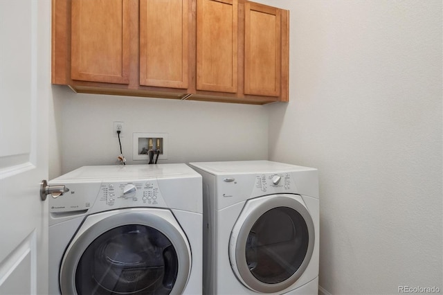 laundry room with independent washer and dryer and cabinet space