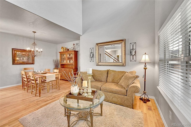 living room with baseboards, wood finished floors, and a chandelier