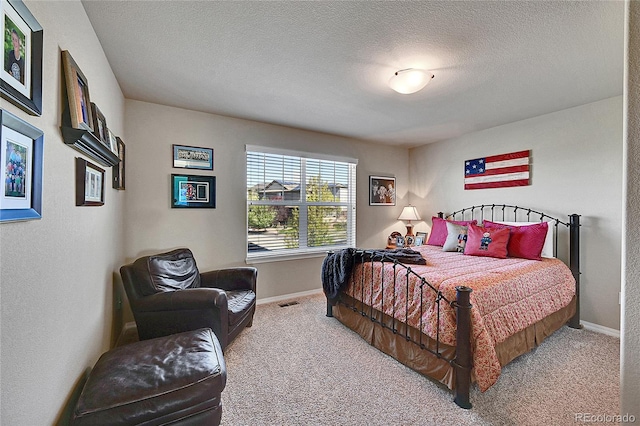 carpeted bedroom featuring baseboards and a textured ceiling