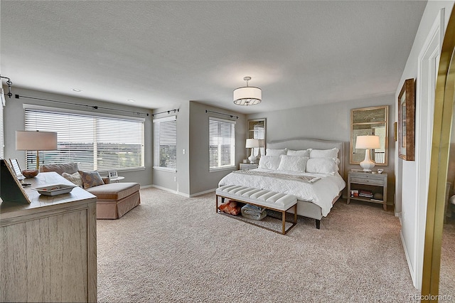 bedroom featuring a textured ceiling, baseboards, and light carpet