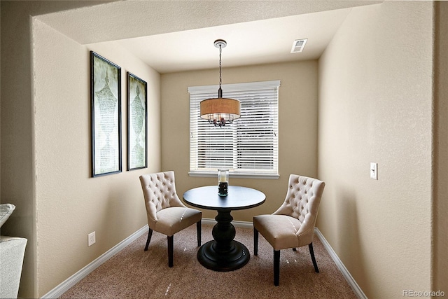 carpeted dining space featuring visible vents, baseboards, and a notable chandelier