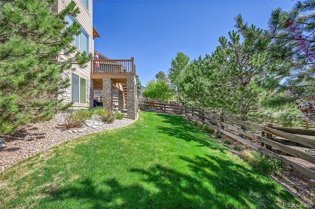 view of yard with fence, a wooden deck, and stairs