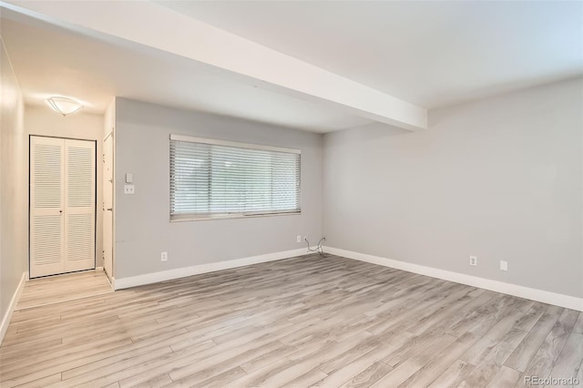 unfurnished room with light wood-type flooring and baseboards
