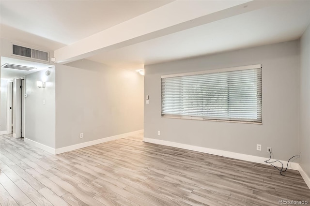spare room featuring wood finished floors and baseboards