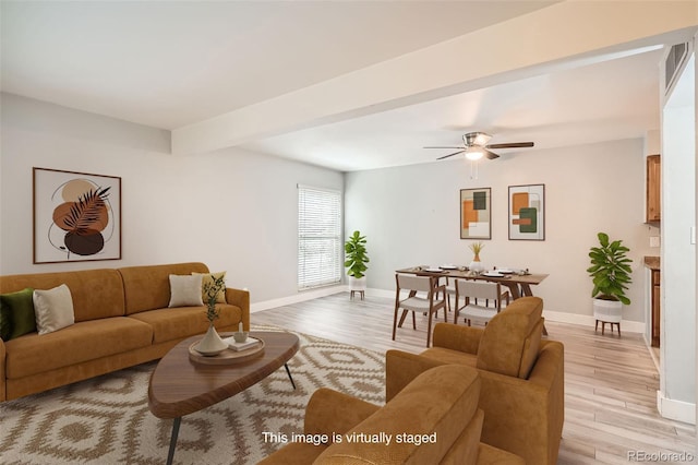 living area featuring light wood-style flooring, baseboards, and ceiling fan