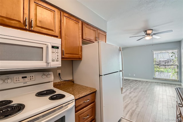 kitchen with white appliances, light wood-style flooring, a ceiling fan, brown cabinetry, and baseboards