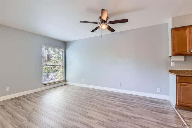 unfurnished living room featuring a ceiling fan, light wood-style floors, and baseboards
