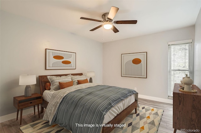 bedroom featuring baseboards, wood finished floors, and a ceiling fan