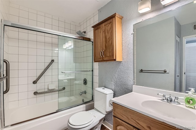 bathroom with a textured wall, shower / bath combination with glass door, toilet, and vanity