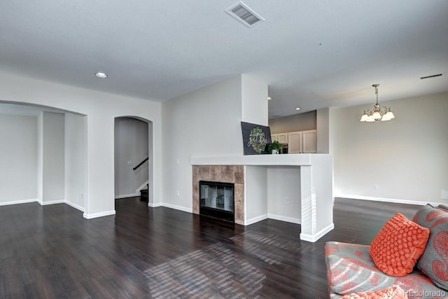 living room featuring a chandelier, a fireplace, and dark hardwood / wood-style flooring