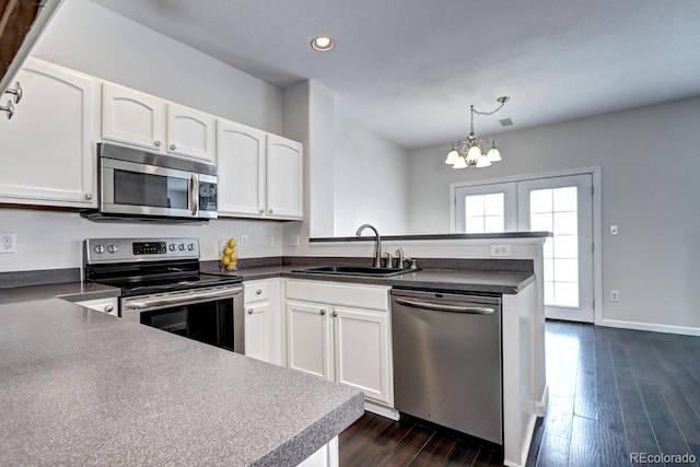 kitchen with dark wood-type flooring, sink, decorative light fixtures, stainless steel appliances, and white cabinets