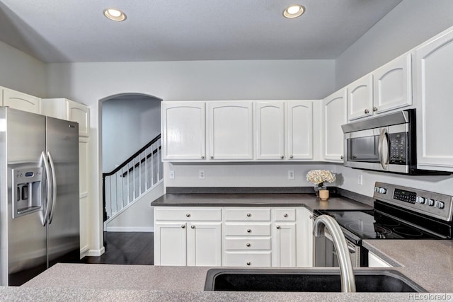 kitchen featuring stainless steel appliances, dark hardwood / wood-style floors, sink, and white cabinets