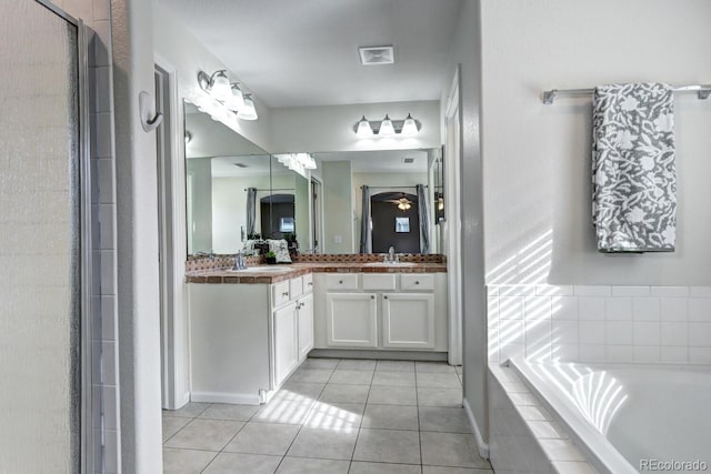 bathroom featuring tile patterned flooring, vanity, and shower with separate bathtub