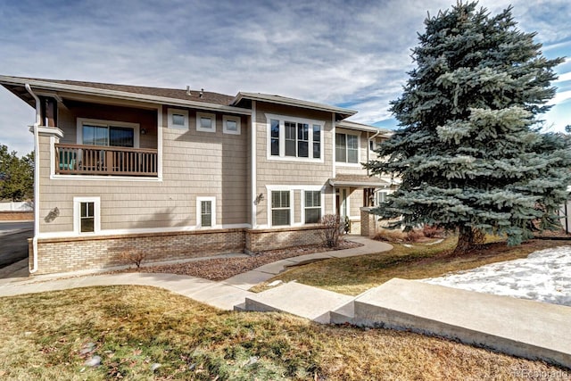 view of front of property with a balcony and a front lawn