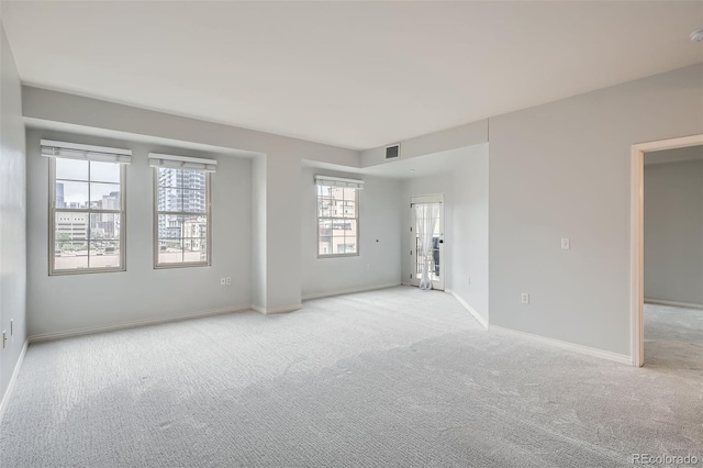 spare room with light colored carpet and baseboards