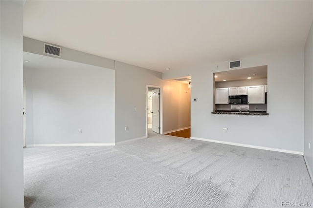unfurnished living room featuring carpet flooring, baseboards, and recessed lighting