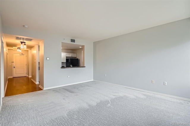 unfurnished living room featuring carpet flooring and baseboards