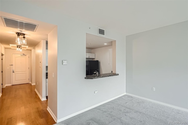 corridor with baseboards and wood finished floors