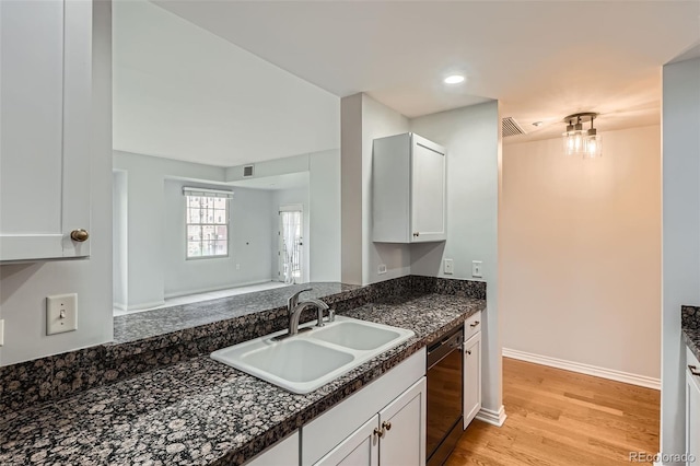 kitchen featuring a sink, black dishwasher, dark countertops, light wood-style floors, and recessed lighting