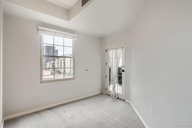 unfurnished room featuring light carpet and baseboards
