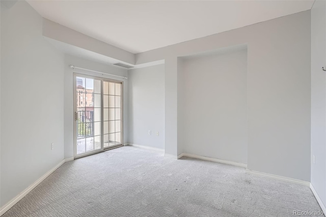 carpeted spare room featuring baseboards