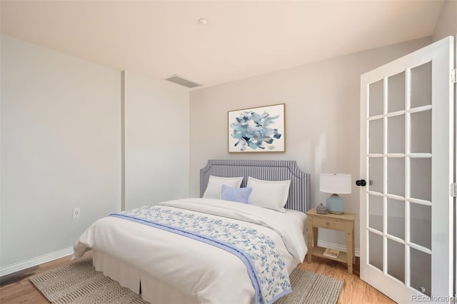 bedroom featuring light wood finished floors and baseboards