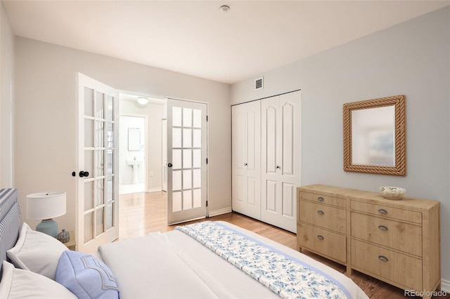 bedroom featuring light wood-type flooring, a closet, baseboards, and french doors