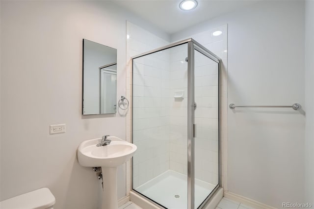 full bathroom featuring a stall shower, toilet, and baseboards