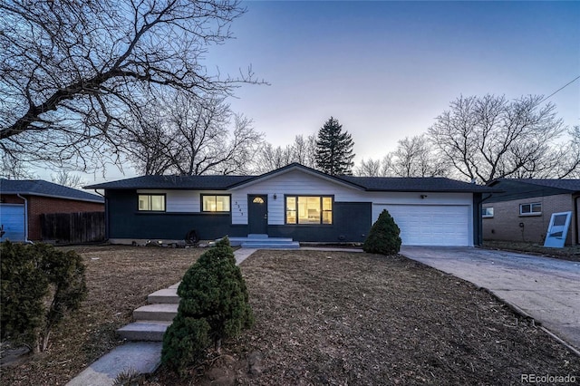 ranch-style house with a garage, brick siding, driveway, and fence