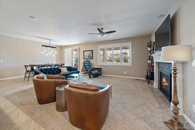 tiled living room featuring ceiling fan with notable chandelier