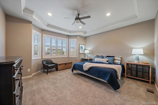 bedroom with carpet flooring, ceiling fan, a raised ceiling, and ornamental molding