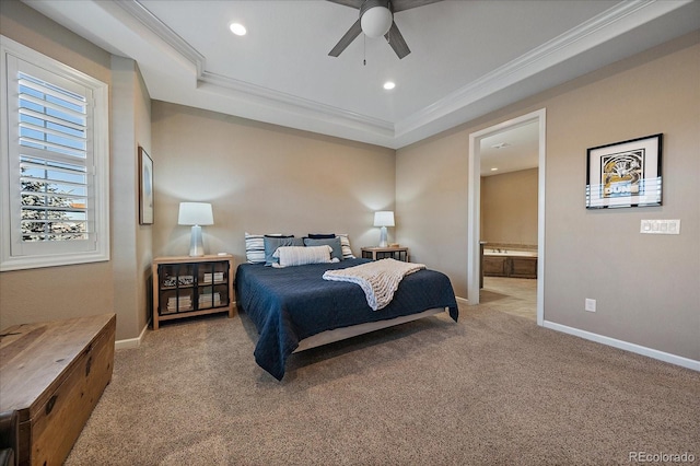 bedroom featuring ceiling fan, ensuite bathroom, light carpet, and a tray ceiling