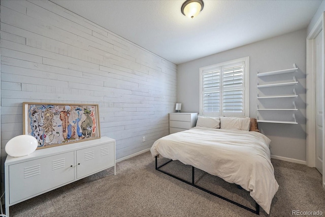 carpeted bedroom featuring brick wall