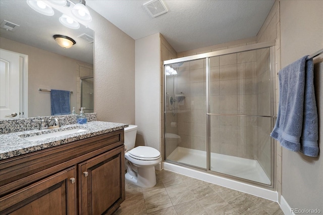 bathroom featuring a textured ceiling, vanity, an enclosed shower, and toilet