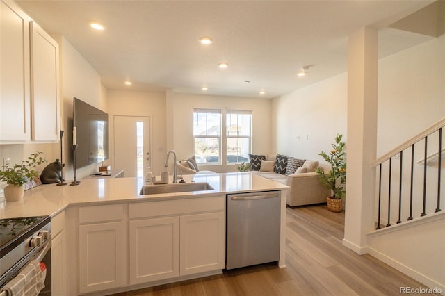 9152 Gladiola Way Unit E, Arvada, CO 80005 - kitchen featuring stainless steel appliances, a sink, a peninsula, light wood-style floors, and white cabinetry
