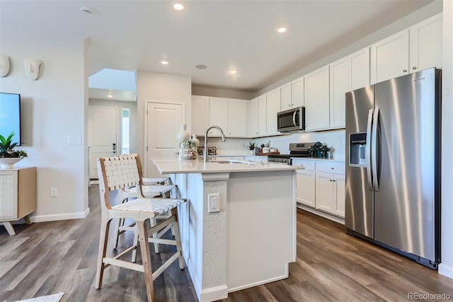 kitchen featuring white cabinetry, appliances with stainless steel finishes, sink, and a center island with sink