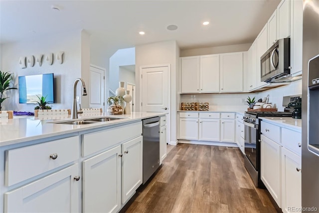 kitchen with stainless steel appliances, dark hardwood / wood-style floors, sink, and white cabinets