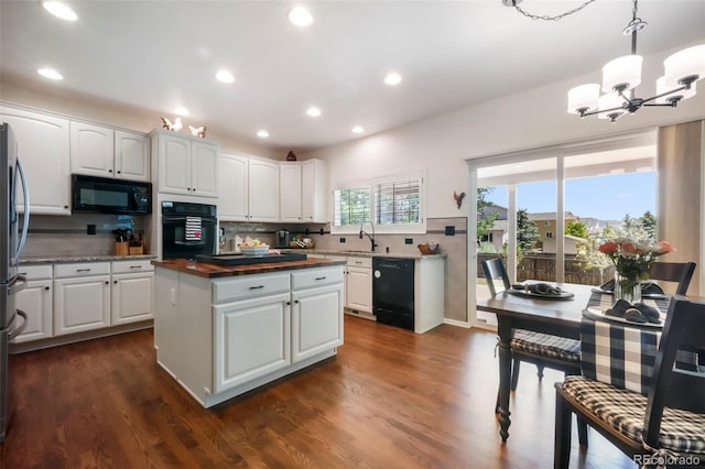 9005 Royal Melbourne Cir, Peyton, CO 80831 - kitchen with black appliances, a chandelier, decorative backsplash, a kitchen island, and white cabinets