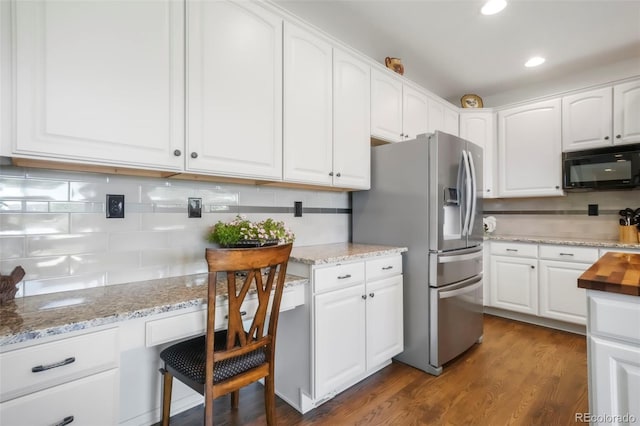 9005 Royal Melbourne Cir, Peyton, CO 80831 - kitchen with black microwave, backsplash, stainless steel fridge, white cabinets, and recessed lighting