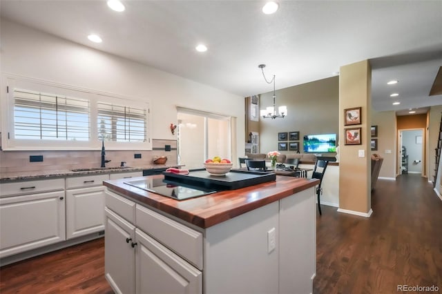 9005 Royal Melbourne Cir, Peyton, CO 80831 - kitchen with wood counters, a chandelier, white cabinetry, dark wood-style flooring, and recessed lighting