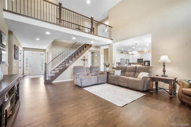 9005 Royal Melbourne Cir, Peyton, CO 80831 - living room with stairs, dark wood-style floors, recessed lighting, a towering ceiling, and a chandelier