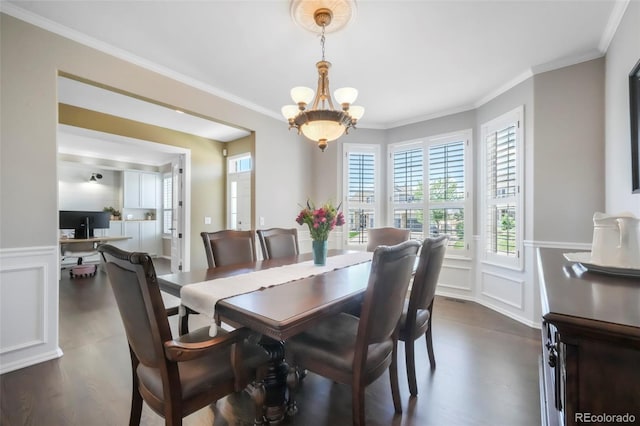 9005 Royal Melbourne Cir, Peyton, CO 80831 - dining space with a decorative wall, dark wood-style floors, a chandelier, crown molding, and a wainscoted wall