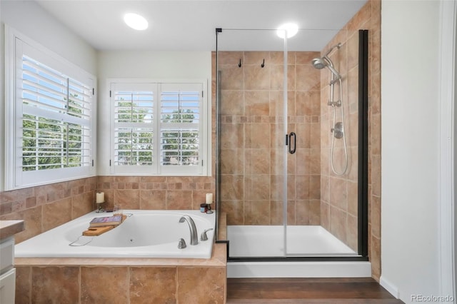 9005 Royal Melbourne Cir, Peyton, CO 80831 - bathroom featuring a whirlpool tub, a stall shower, wood finished floors, and vanity