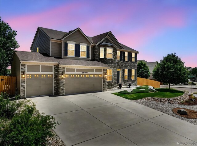 9005 Royal Melbourne Cir, Peyton, CO 80831 - view of front of property featuring stone siding, concrete driveway, and an attached garage