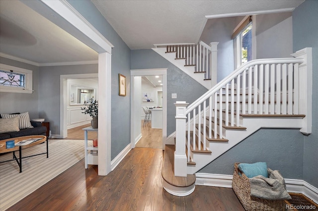 stairs with ornamental molding and wood-type flooring